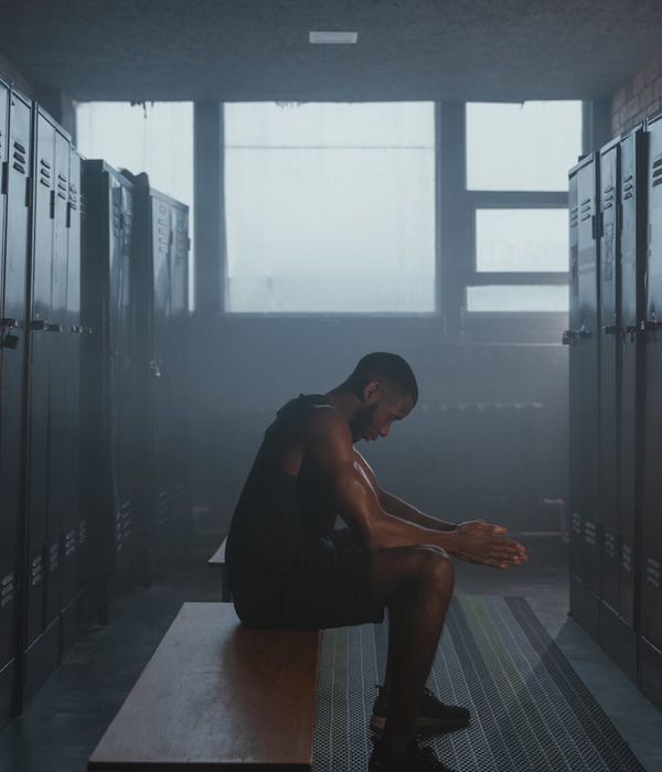 Strong man performing morning energy exercises in a dark room